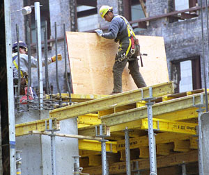 A construction worker holding a wooden board