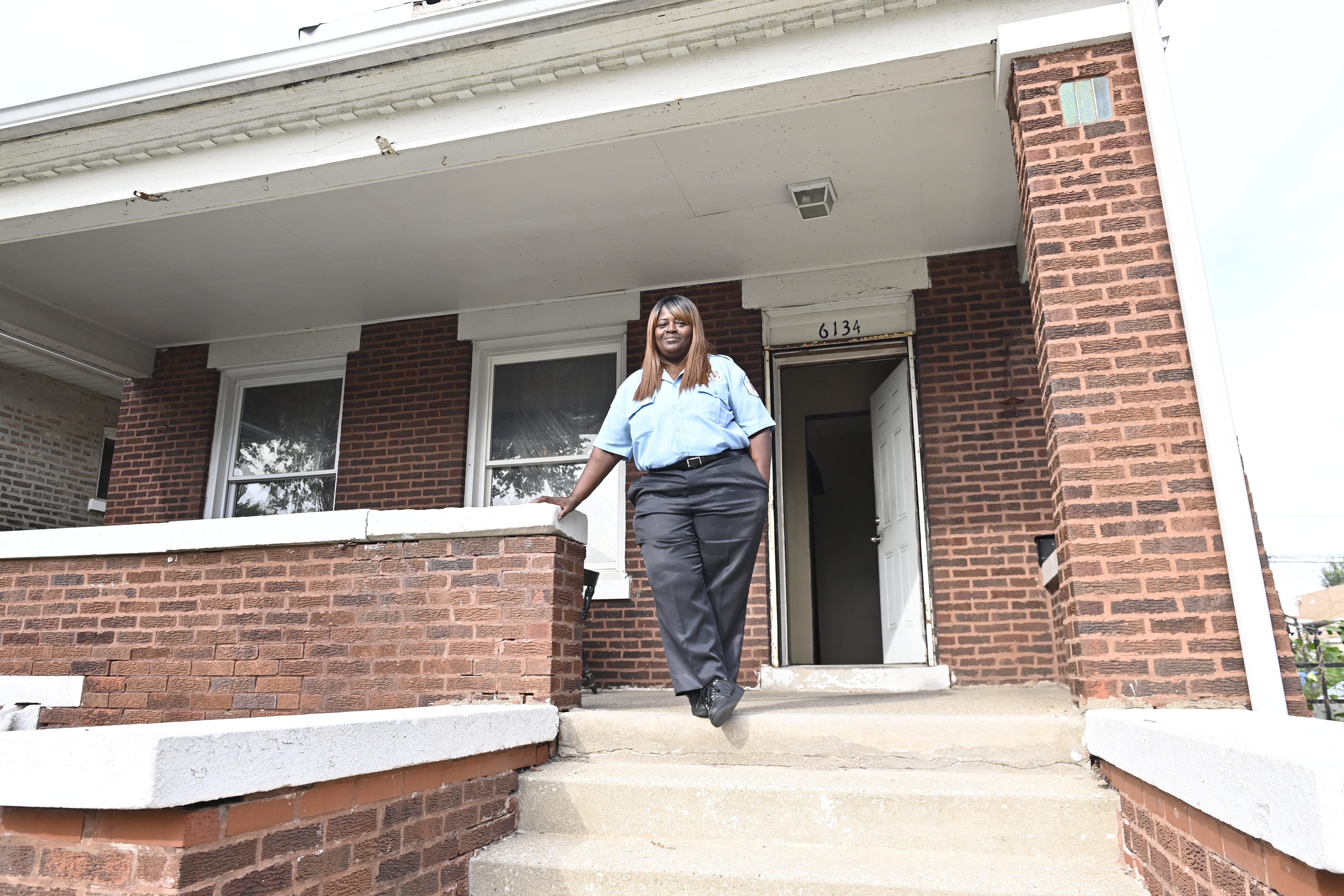 Woman in security uniform on porch.