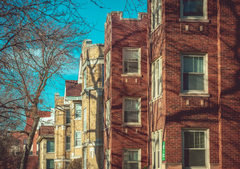 A row of brick 2-flat buildings in a Chicago neighborhood